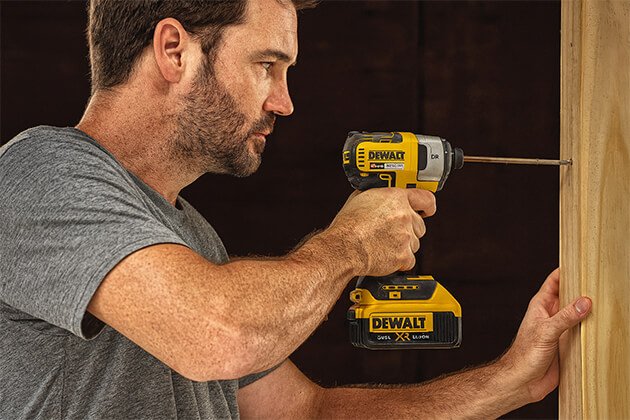 Homme utilisant une visseuse à chocs sans fil DeWalt XR 18V pour visser dans du bois